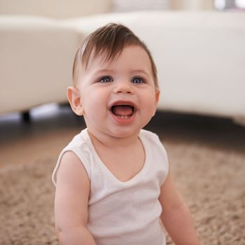 Delightfully adorable. a baby boy sitting on the carpet at home