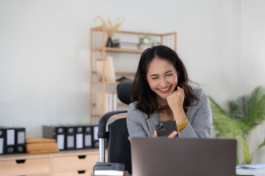 Happy excited asian woman celebrate with computer laptop, success or happy action. Freelancer or Entrepreneur using technology and start up modern home