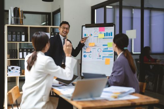 Business adviser explaining business plan strategy on flipchart to colleagues, male coach or adviser giving presentation at briefing, reporting about results or growing sales.