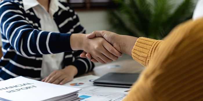 Business people shaking hands, finishing up meeting about financial