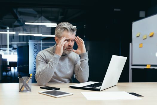 Senior thinking businessman working inside office with laptops, man thinking about important financial decision.