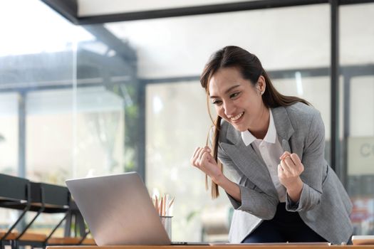 Excited happy Asian woman looking at the phone screen, celebrating an online win, overjoyed young asian female screaming with joy, isolated over a white blur background.