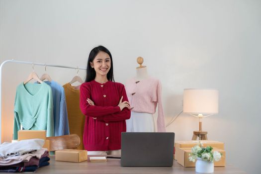 Portrait of Starting small businesses SME owners, Asian woman check online orders Selling products working with boxs freelance work at home office, sme business online small medium enterprise..