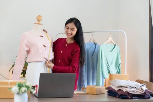 Portrait of Starting small businesses SME owners, Asian woman check online orders Selling products working with boxs freelance work at home office, sme business online small medium enterprise..