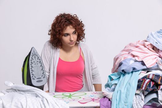 A woman wonders how to get down to ironing such a large amount of clothing. The surprised look on the girl's face before starting her homework.