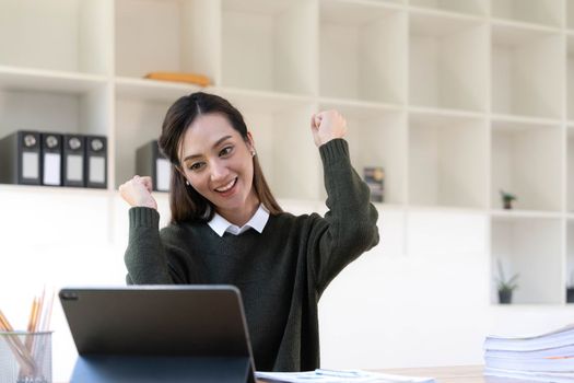 Pretty Asian businesswoman sitting on a laptop And the work came out successfully and the goal was achieved, happy and satisfied with her