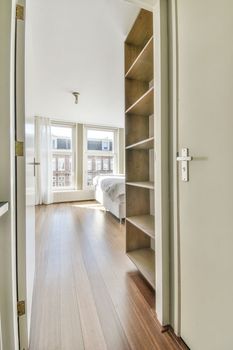 White hallway with wooden stairway leading to second floor of modern luxury apartment with minimalist interior design