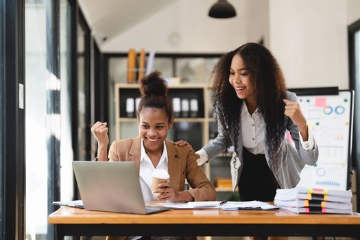 Excited african women achieving goals excited raised hands rejoicing with laptop in the office. New startup project concept