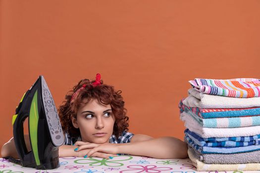 A girl glances at the ironed towels. A woman with big beautiful eyes. It's time to relax after doing the daily work at home.