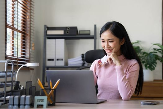 Happy asian Business woman pay online using mobile phone at the home