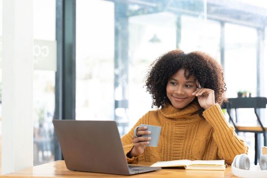 Photo of cheerful joyful woman in yellow shirt smiling work on laptop talk speak video call online. Smart ethnic female in earphones study distant on computer at home. Education concept...