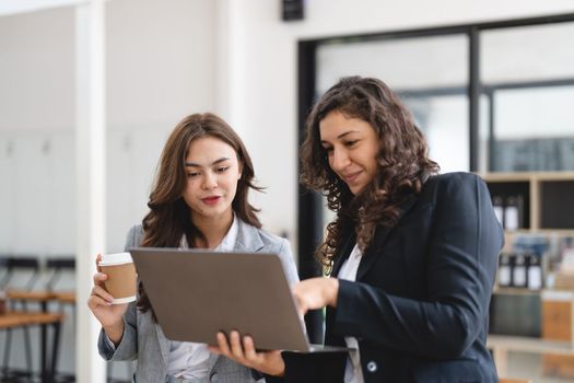 Diverse businesspeople cooperate work together discussing company financial statistics, multiracial colleagues collaborate brainstorm with finance on tablet