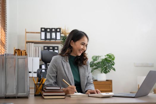 Asian woman working laptop for business financial analysis on laptop computer at office