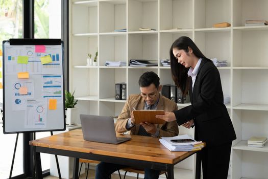 Asian business adviser meeting to analyze and discuss the situation on the financial report in the meeting room.Investment Consultant, Financial advisor and accounting concept.