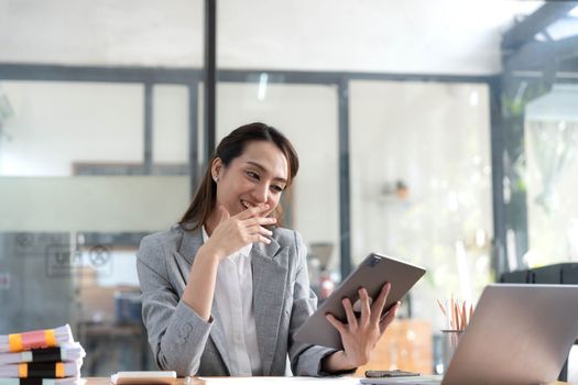 Excited happy Asian woman looking at the phone screen, celebrating an online win, overjoyed young asian female screaming with joy, isolated over a white blur background.