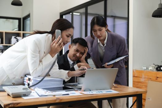 Stressed businesspeople, Frustrated and upset in business pressure and overworked at office. Adult Asian man and woman working on laptop, feeling tire and headache. Stressed and Frustrated concept.