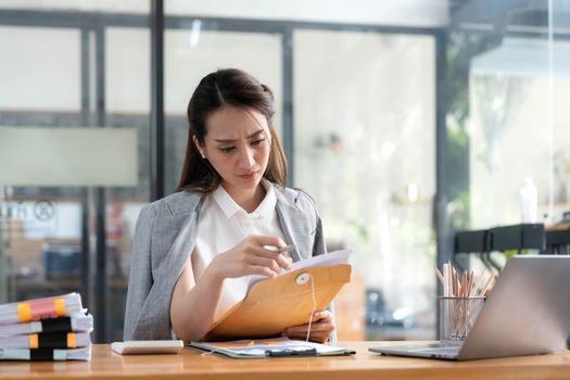 Young Business Asian women are stressed while working on laptop, Tired asian businesswoman with headache at office, feeling sick at work copy space in workplace an home office..