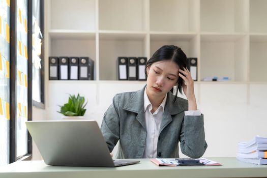 asian woman thinking hard concerned about online problem solution looking at laptop screen, worried serious asian businesswoman focused on solving difficult work computer task..