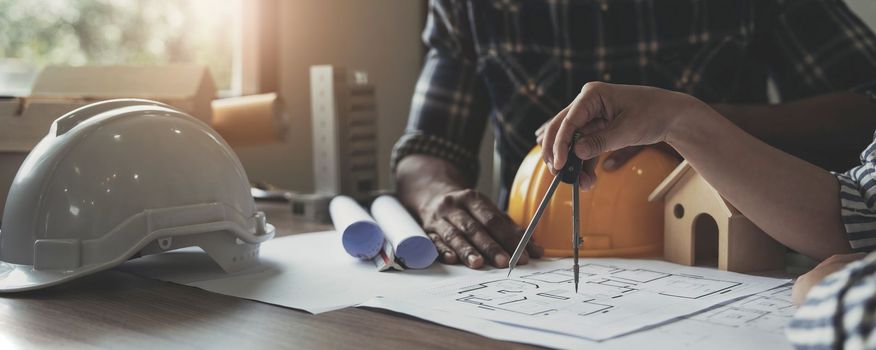 Builder two asian young engineer man and architect woman are discussing construction from a plan to follow the project to build an industrial plant at site. Worker concept..