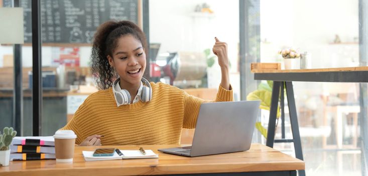 Asian woman celebrate with laptop, success happy pose. E-commerce, University education, internet Technology, or startup small business concept. Modern office or living room with copy space.