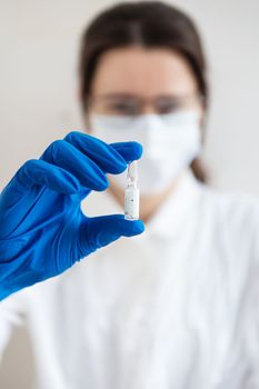 The concept of the new coronavirus COVID-19,2019-nCoV. Ampoule with a vaccine in a doctor's hand, close-up