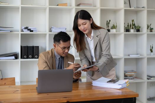 Asian business adviser meeting to analyze and discuss the situation on the financial report in the meeting room.Investment Consultant, Financial advisor and accounting concept.