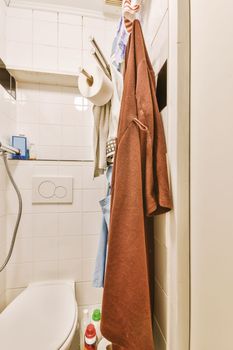 a bathroom with a towel hanging on the wall next to a toilet and a roll of toilet paper in it