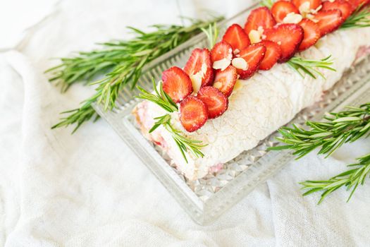 The process of making a meringue roll. Cooking a meringue roll in the kitchen. Meringue roll with strawberries and decorated with rosemary