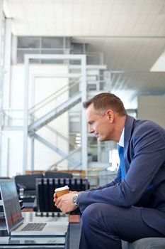 Email, coffee and businessman with a laptop for work, communication and internet. Business, working and employee reading news, information and corporate chat on a computer with tea in an office.