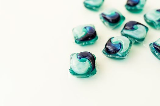 Washing powders in multi-colored capsules on a white background. The concept of washing and cleanliness. Place for an inscription