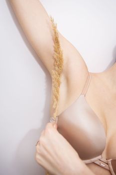 The girl carries a dried flower under her armpit. skin smoothness concept. Laser hair removal, spa treatment