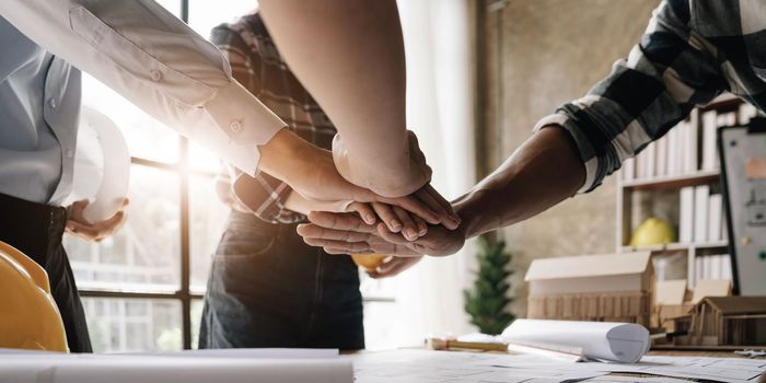 Team of engineer and architects working join hands to build successful projects. Teamwork concept