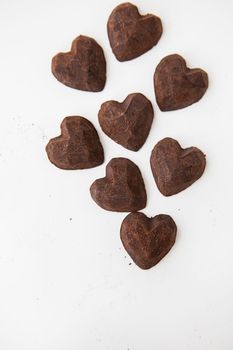 Truffle chocolate candies in the form of a heart on a white background. Place for an inscription