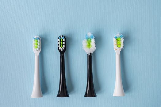 Modern electric toothbrush standing on a blue background, time to change the brush-old and new brush head. A controlled product for daily care of the oral cavity. Hygiene concept