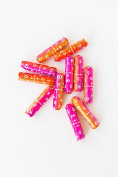 Medical female tampon in pink and orange packaging on a white background. Hygienic white tampon for women. Cotton swab. Menstruation, contraception