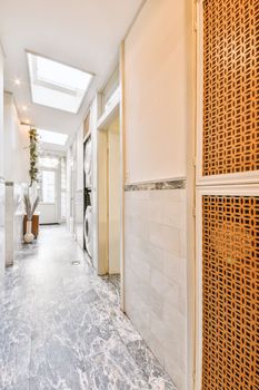 a long hallway with tiled flooring and wall panels on the walls that have been painted to look like woven weaves