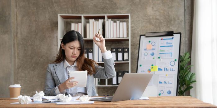 asian woman thinking hard concerned about online problem solution looking at laptop screen, worried serious asian businesswoman focused on solving difficult work computer task..