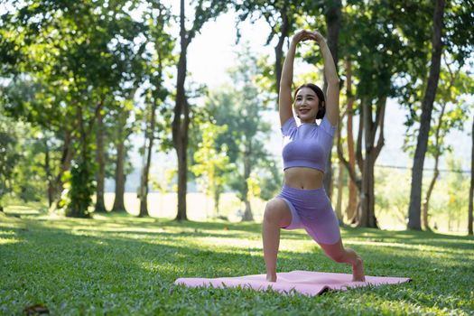 Mature healthy people doing yoga at park. Asian woman exercising on green grass with yoga mat