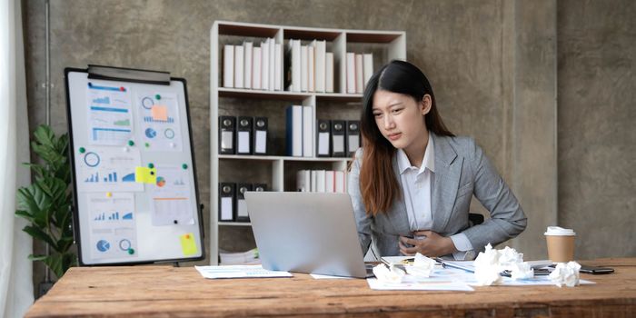asian woman thinking hard concerned about online problem solution looking at laptop screen, worried serious asian businesswoman focused on solving difficult work computer task..
