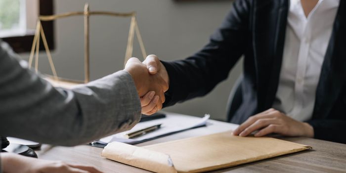 Closeup businesswoman Shaking hands with lawyer after discussing good deal in office..