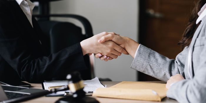 Closeup businesswoman Shaking hands with lawyer after discussing good deal in office..