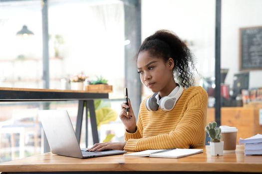 Young woman student using computer and mobile device studying online. Education and online learning..