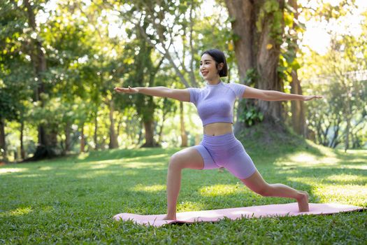 Portrait of a young woman doing yoga in the garden for a workout. Concept of lifestyle fitness and healthy. Asian women are practicing yoga in the park