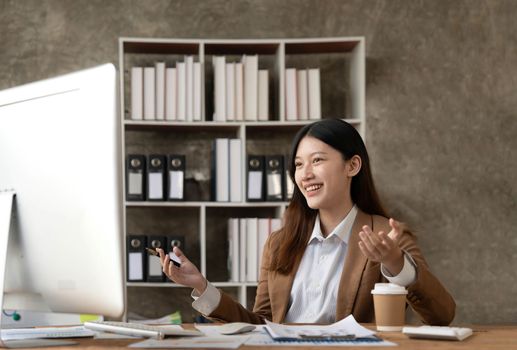 Young woman working on a laptop in the office. Asian businesswoman sitting at her workplace in the office. Beautiful Freelancer Woman working online