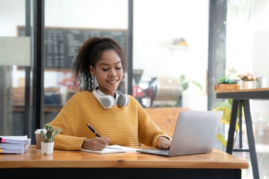 Young woman student using computer and mobile device studying online. Education and online learning..