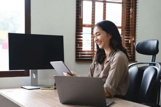 Asian woman accountant preparing annual financial report checking result on calculator bookkeeping. female freelancer counting tax rates declaring income.