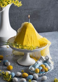 Traditional Easter Orthodox curd cake with yellow flowers on a grey table, High quality photo