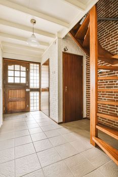 an empty house with wood and white brick walls on either side of the room, there is a staircase leading up to the door