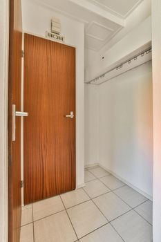 Wall hung toilet and small sink in corner in lavatory room with beige tile