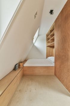 a bedroom with a bed and cupboards on the wall next to each other room in an attic style home